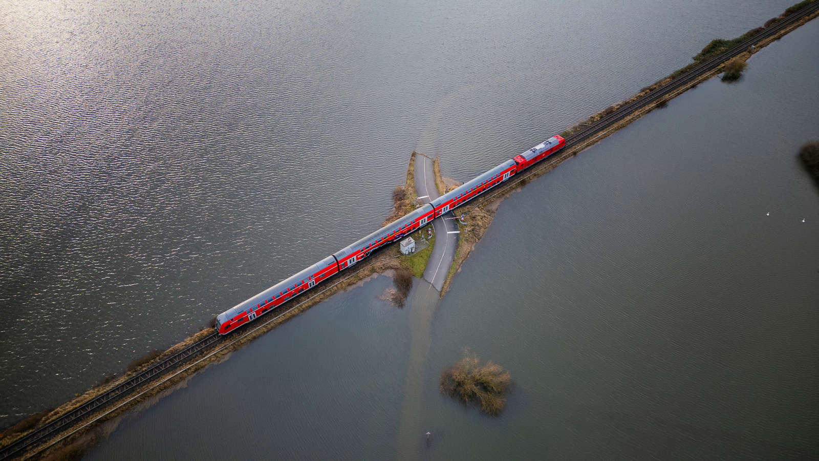 33501457-ein-regionalbahn-faehrt-auf-einem-schienendamm-der-komplett-von-wasser-eingeschlossen...jpg