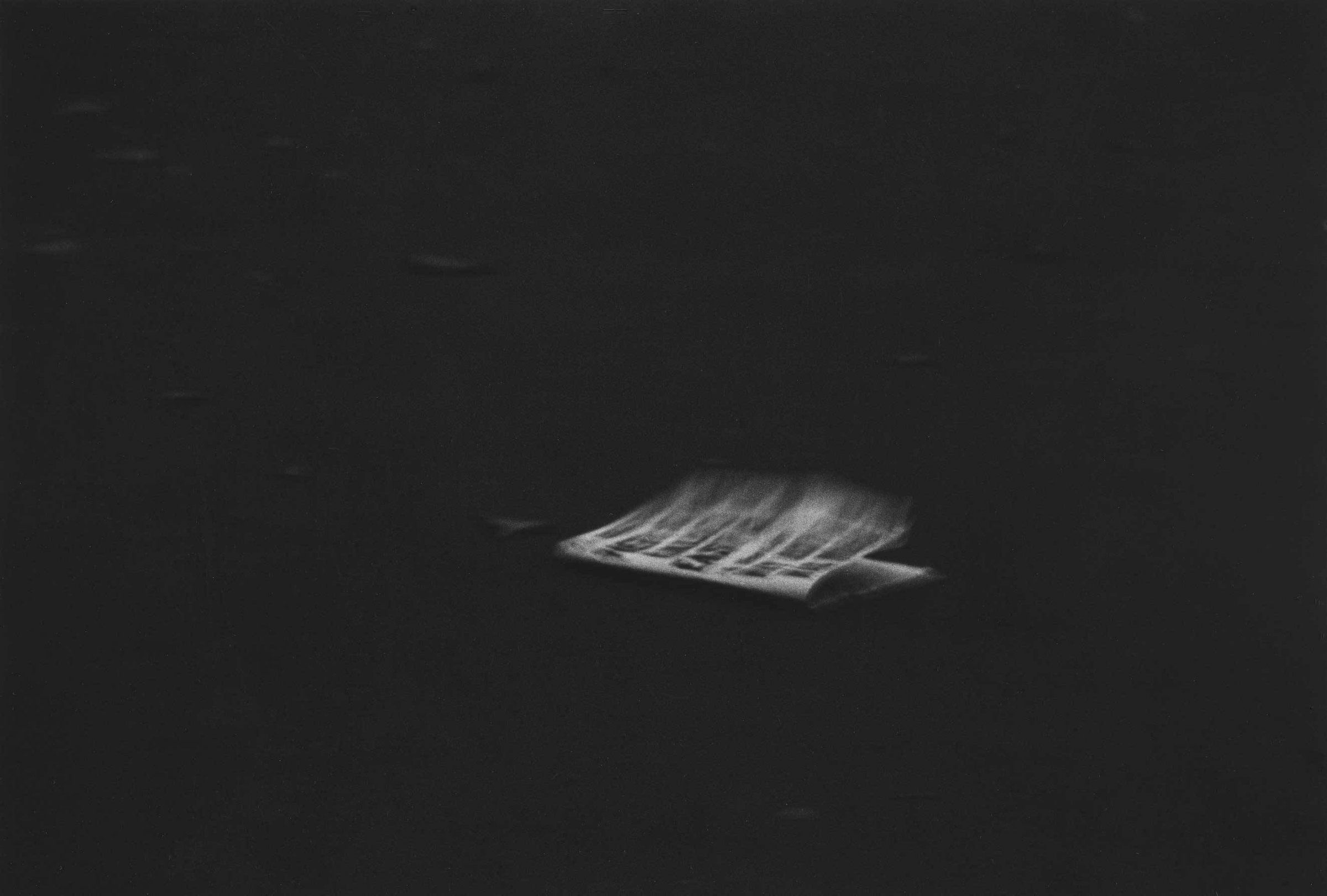 Diane Arbus - Windblown headline on a dark pavement, NYC 1956.jpg