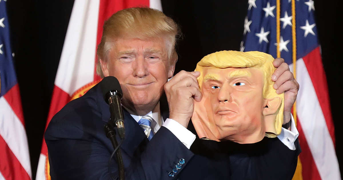 Donald Trump Holds Trump Mask Onstage at Florida Rally).jpg